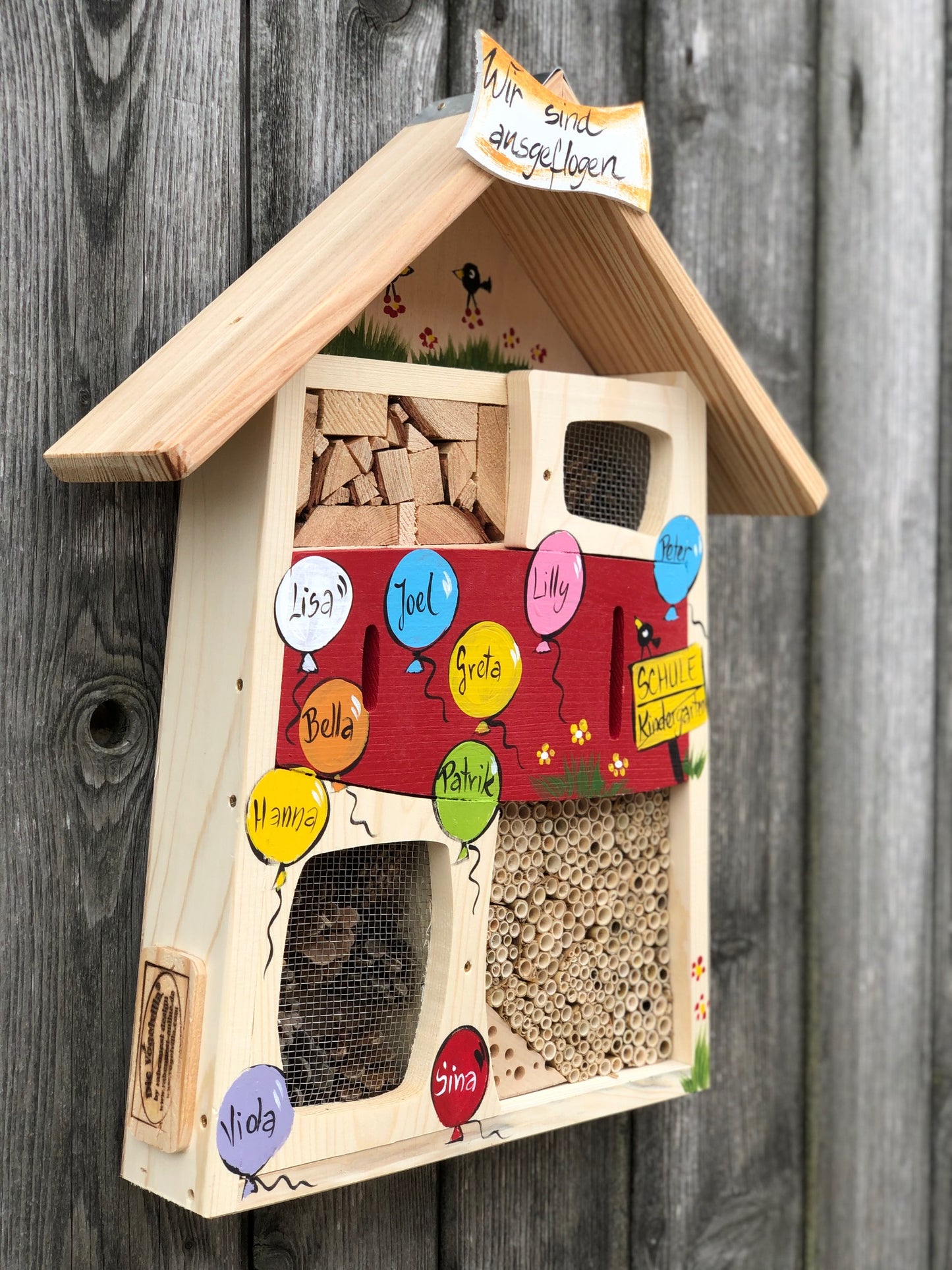 Cadeau d'adieu pour l'enseignante de maternelle : hôtel à insectes rouge avec les noms des enfants dans des ballons colorés